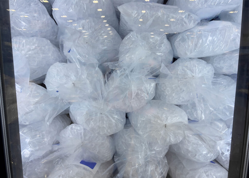 Clear bags of ice neatly stacked inside a freezer, ready for pickup or delivery by Midwest Ice Masters in Wichita, Kansas.